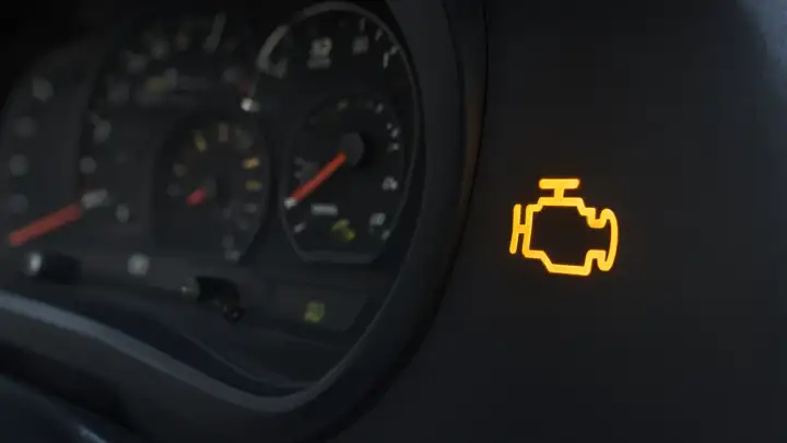 Illustration: amber check engine light on a car dashboard